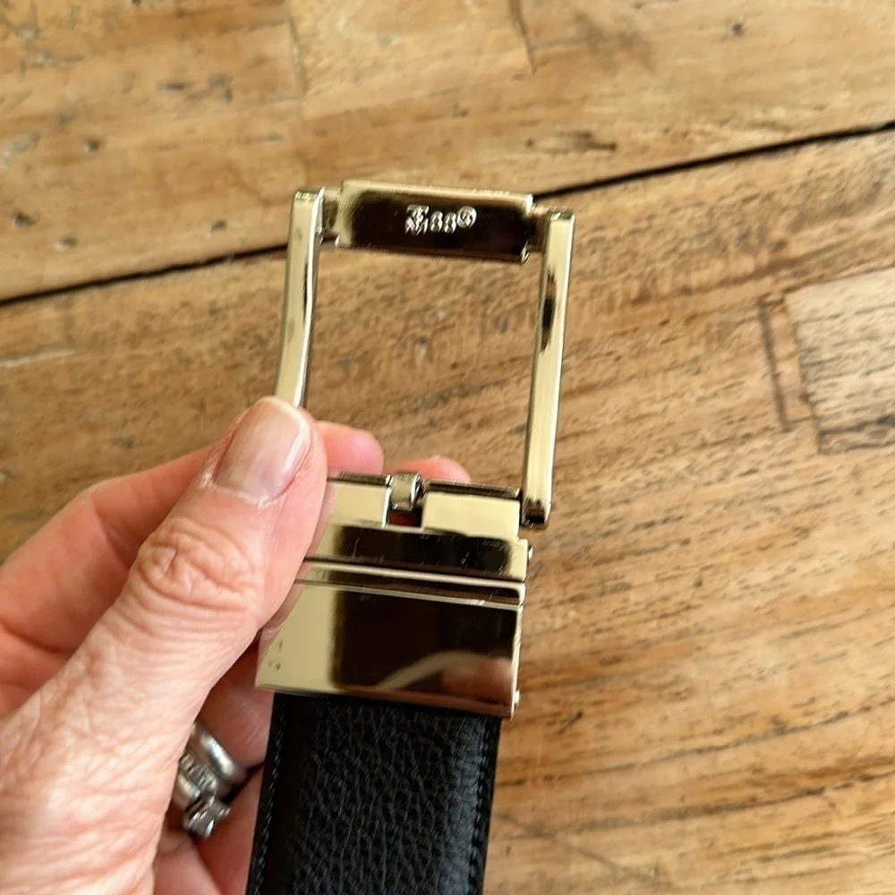 Reversible black and tan belt with silver buckle. Size 32.